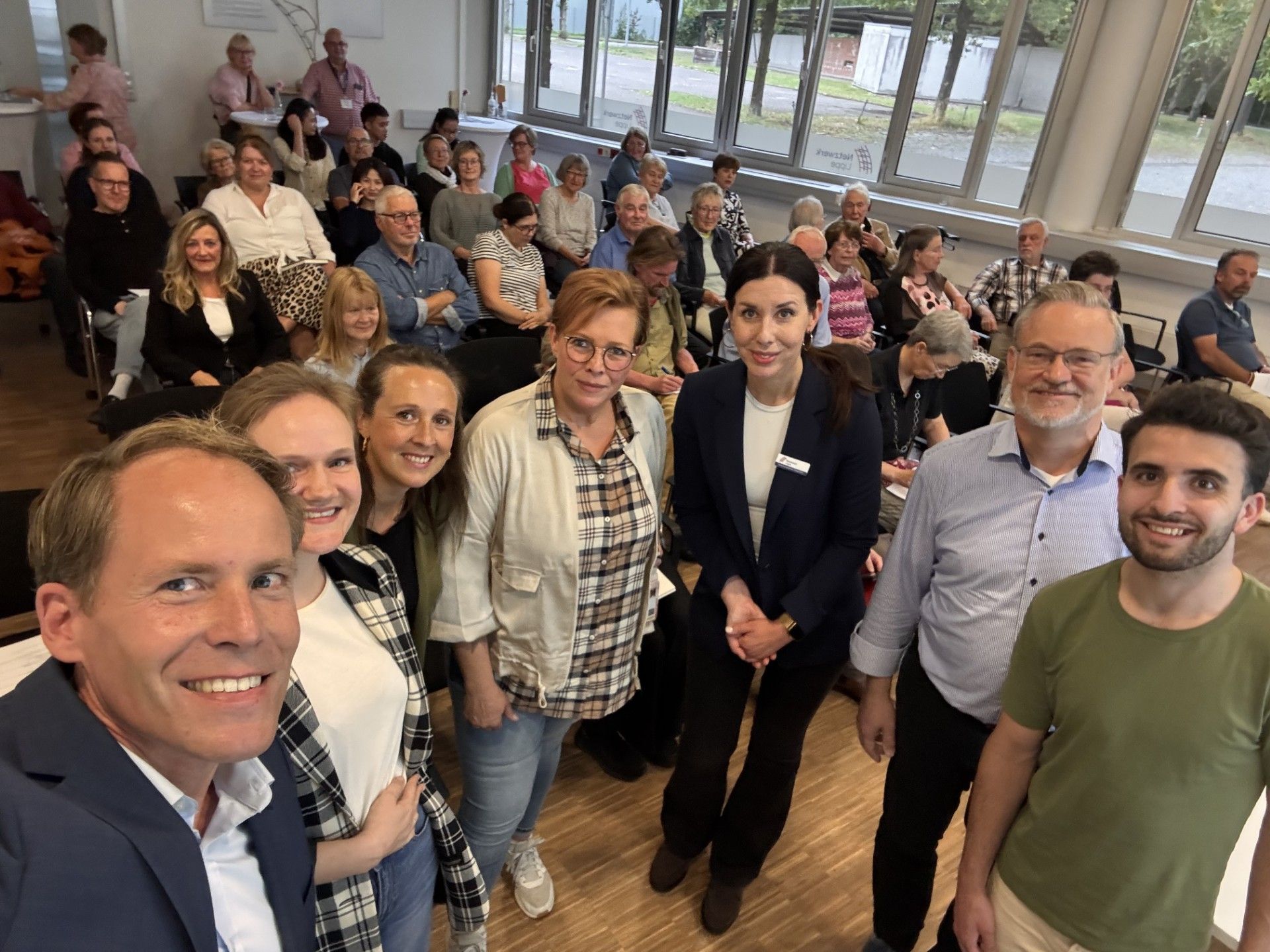 Gruppe von jungen Menschen und Betreuern lächeln gemeinsam.